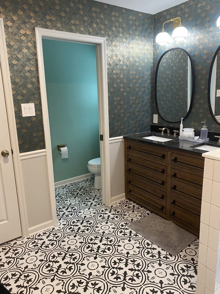 A bathroom with two sinks , two mirrors and a toilet.