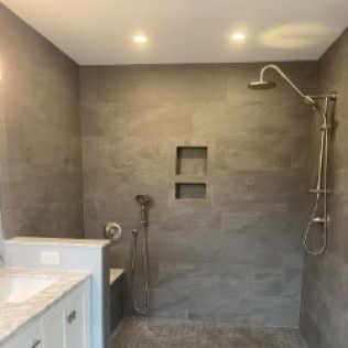 A bathroom with a walk in shower and a sink.