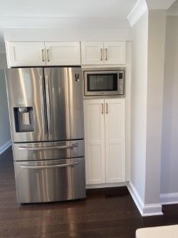 A kitchen with stainless steel appliances and white cabinets