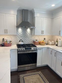 A kitchen with white cabinets and stainless steel appliances.