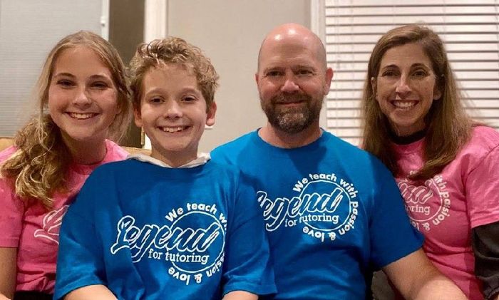 Family of four wearing matching Legend for Tutoring t-shirts, smiling.