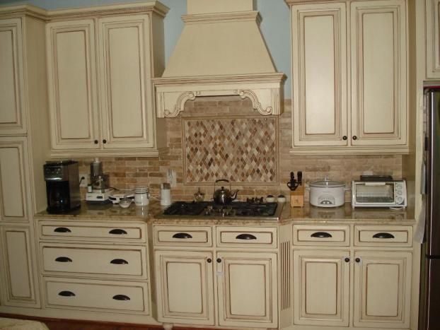 A kitchen with white cabinets and a stove top oven