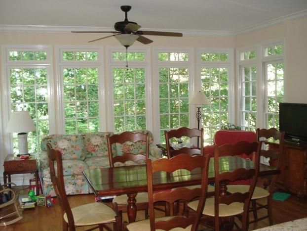 A living room with a table and chairs and a ceiling fan