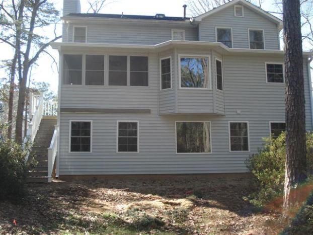 A large house with a lot of windows is surrounded by trees