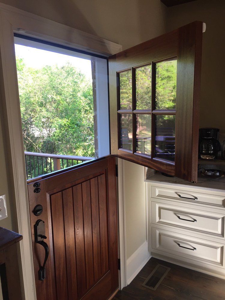 A kitchen with a wooden door and a window.
