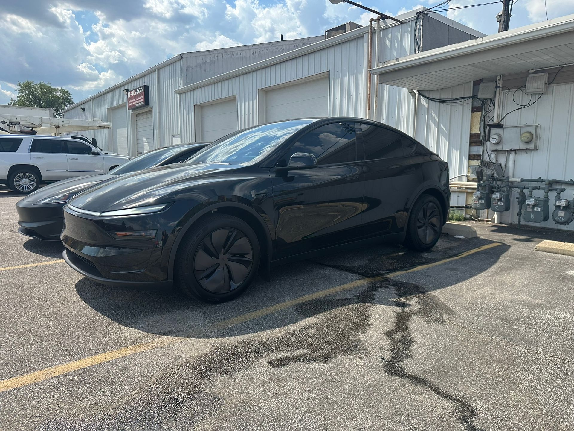Black Tesla Model Y parked outside a building.