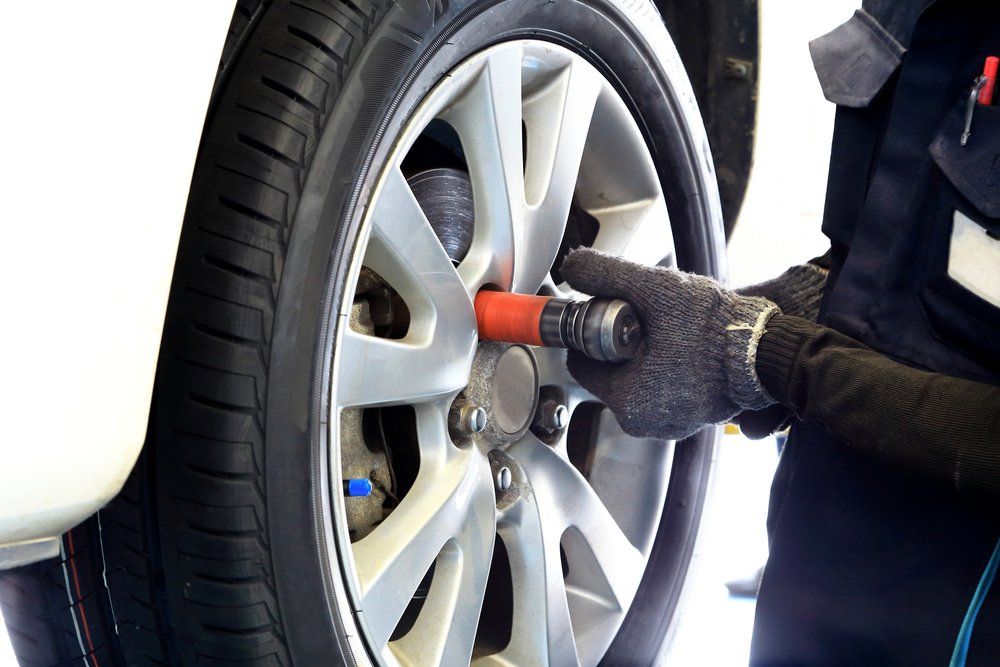 A close up shot of a tyre being put onto a car.