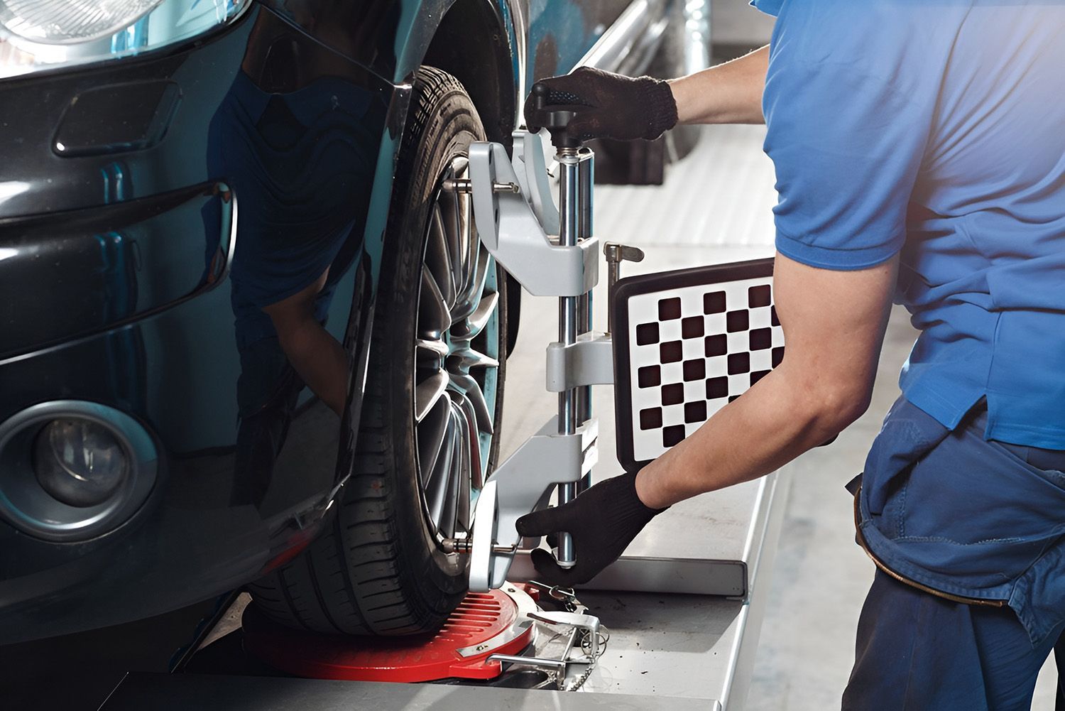 Mechanic Aligning A Car's Wheel With A Machine