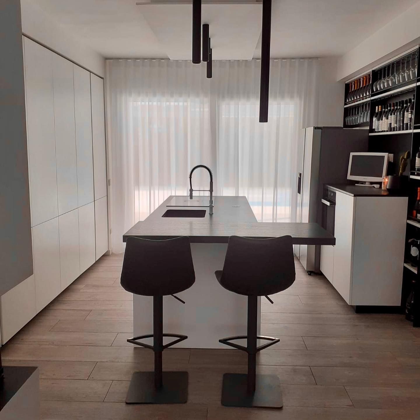 Una cucina con una grande isola e due sgabelli da bar