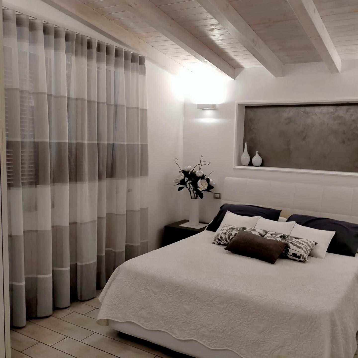 Una camera da letto con un letto e una finestra con tende