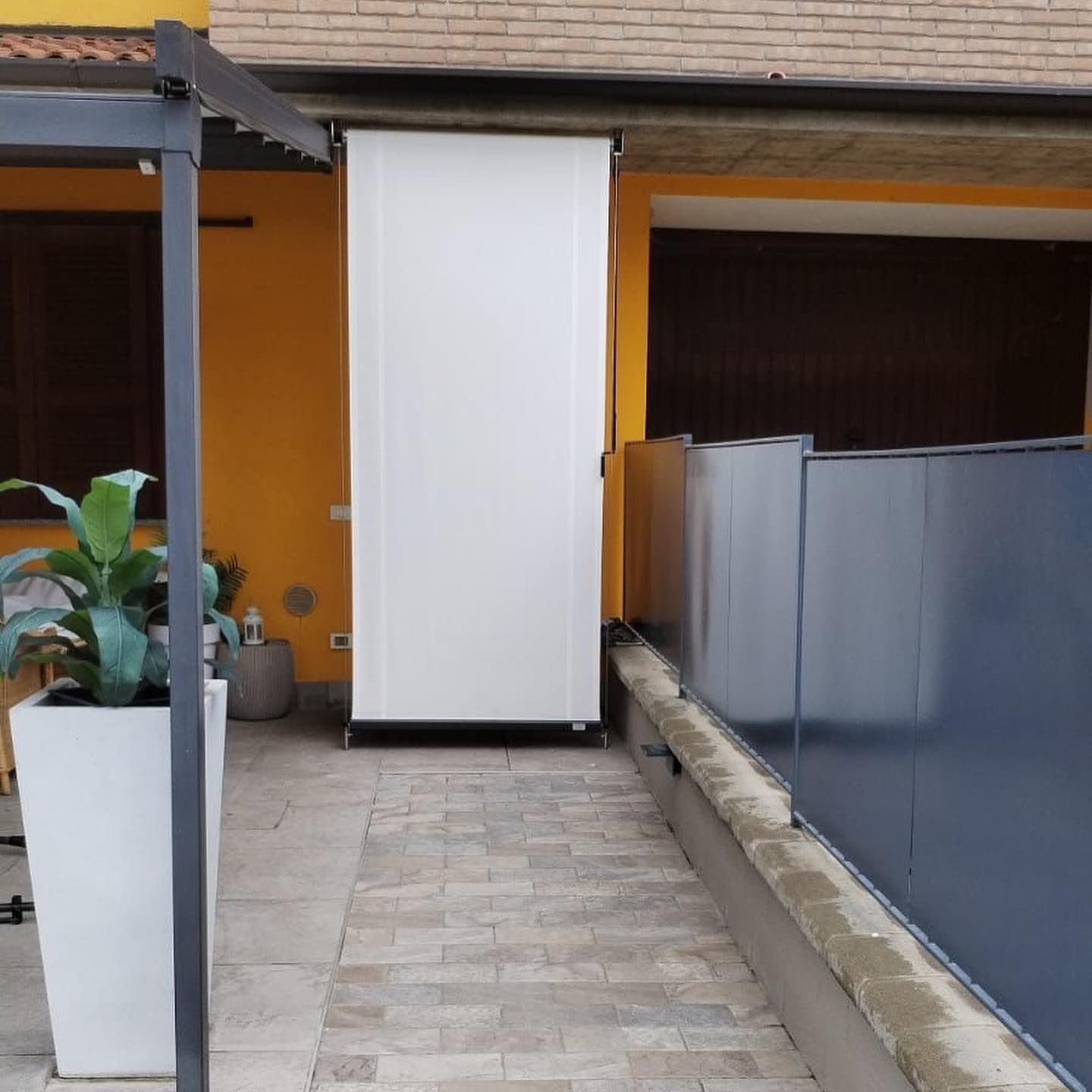 Un edificio in mattoni con una recinzione e delle fioriere davanti