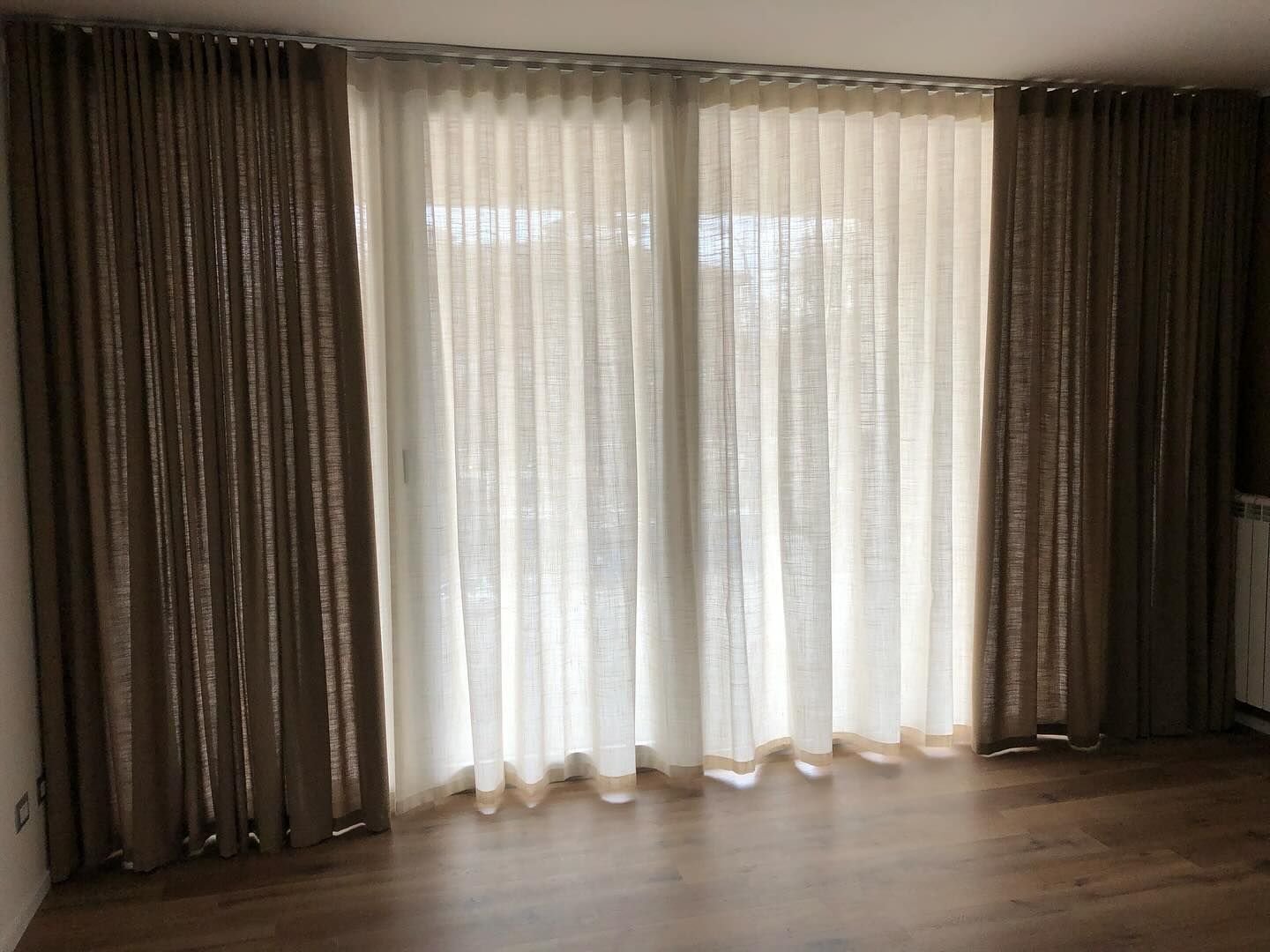 Un soggiorno con una porta scorrevole in vetro e tende.