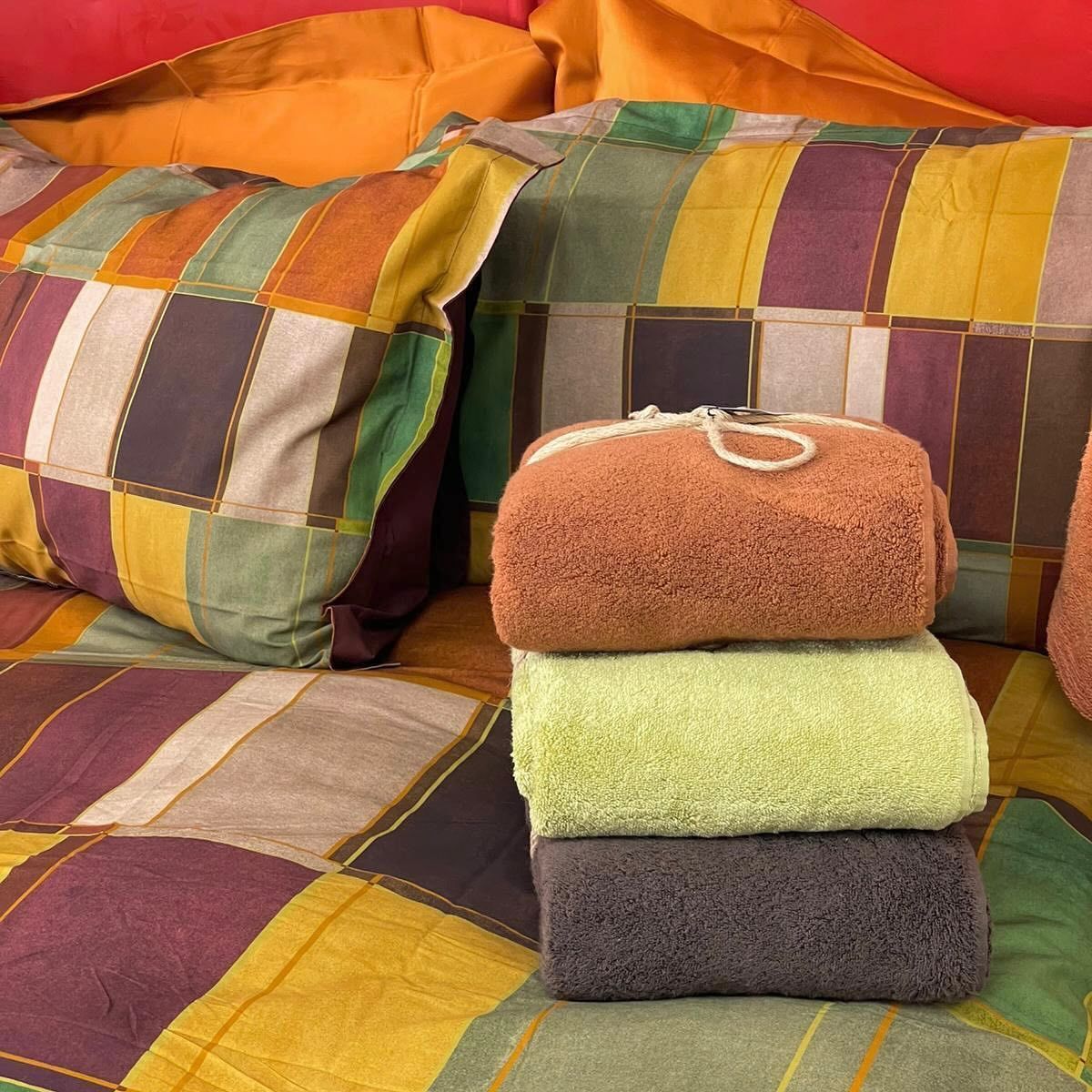 Quattro asciugamani sono impilati uno sopra l'altro su un letto