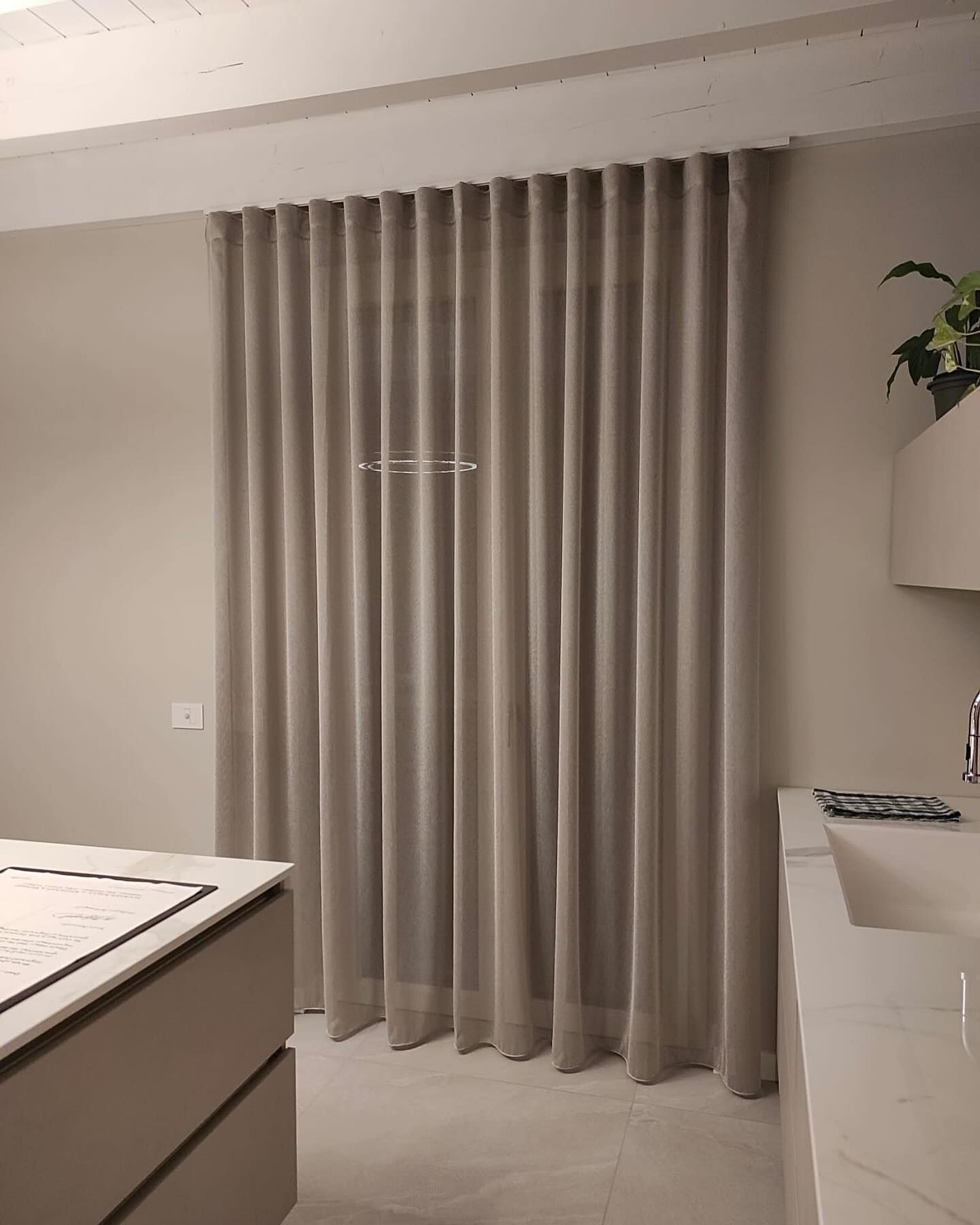 Una cucina con un lavandino e tende alla finestra