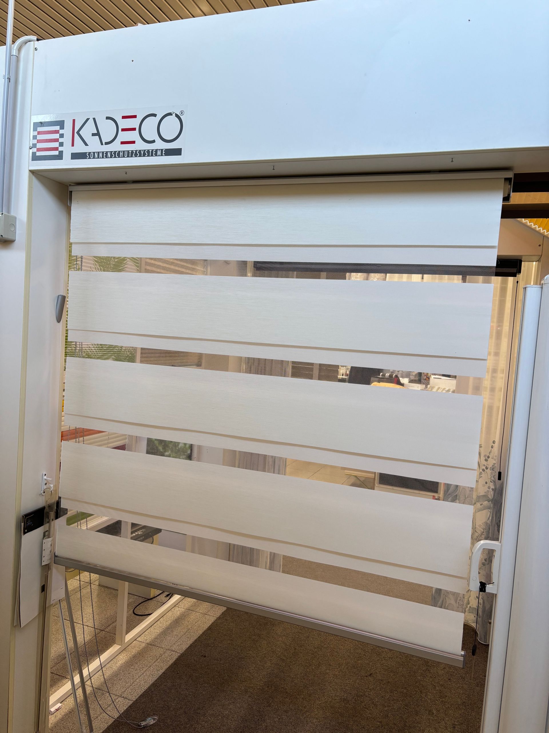 Una tapparella bianca con la scritta kadeco sopra