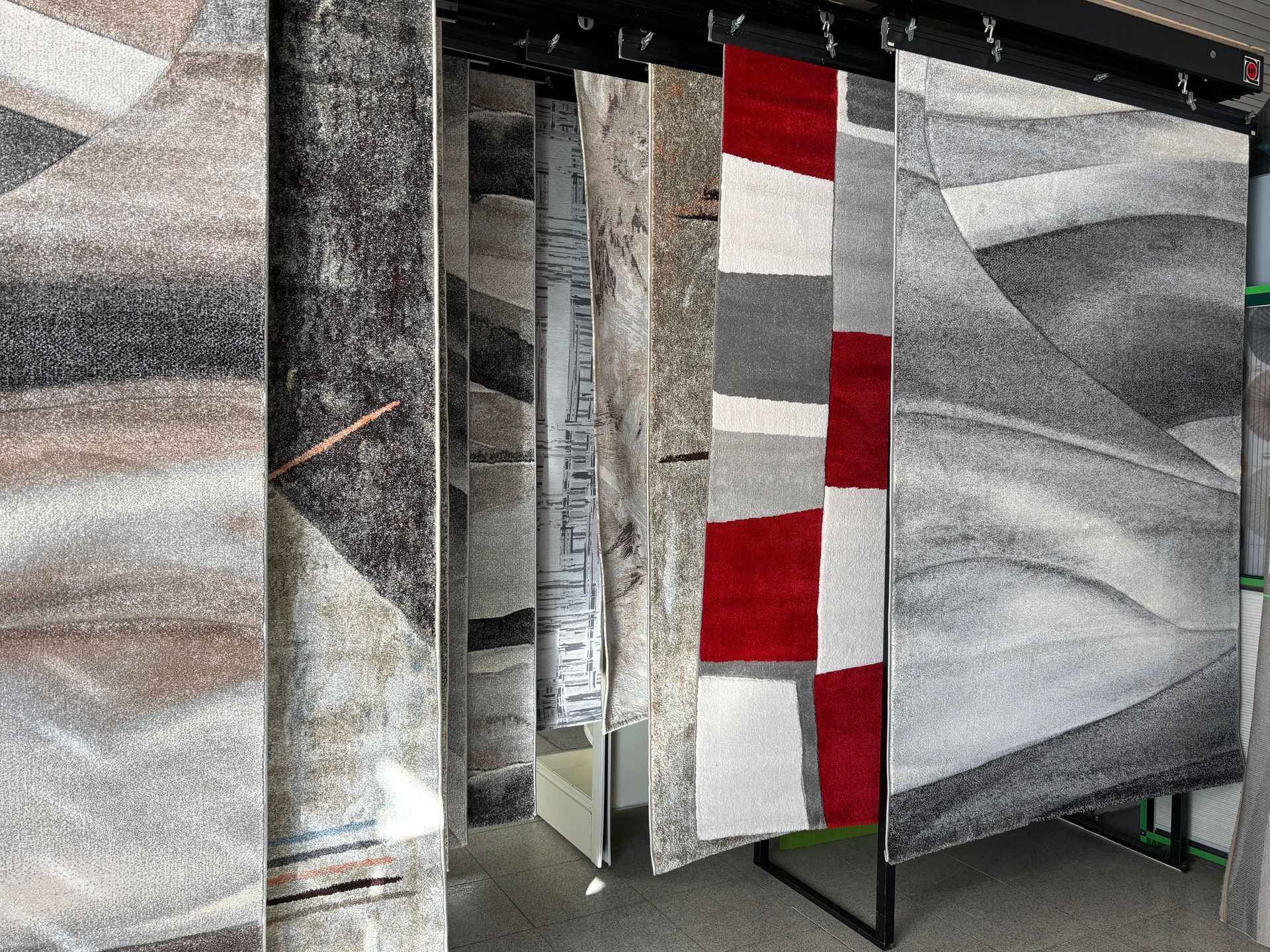 Un mucchio di tappeti è appeso su un attaccapanni in una stanza.