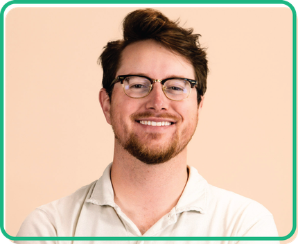 A man with glasses and a beard is smiling for the camera