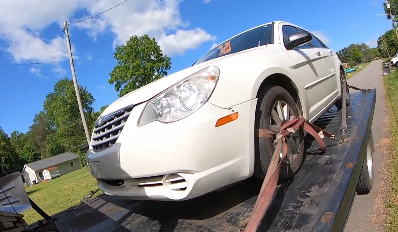 Car loaded and strapped on flatbed tow truck