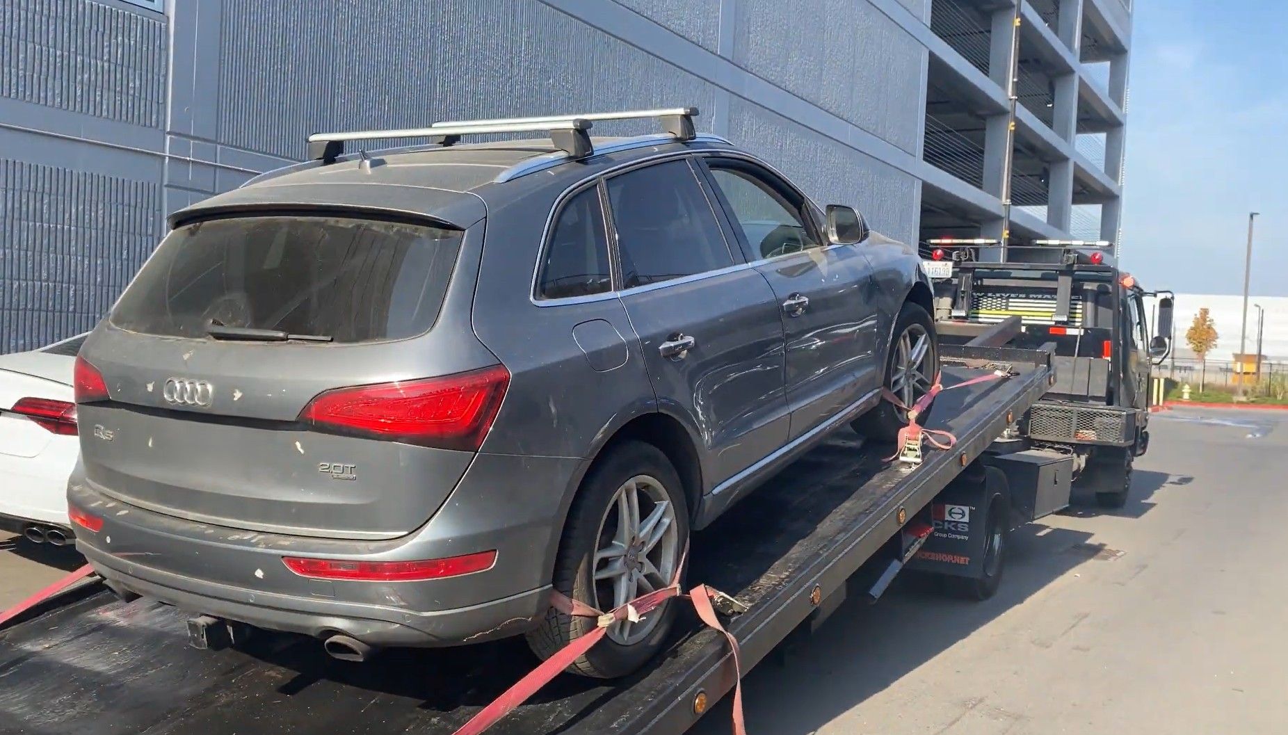 SUV loaded and strapped on flatbed tow truck