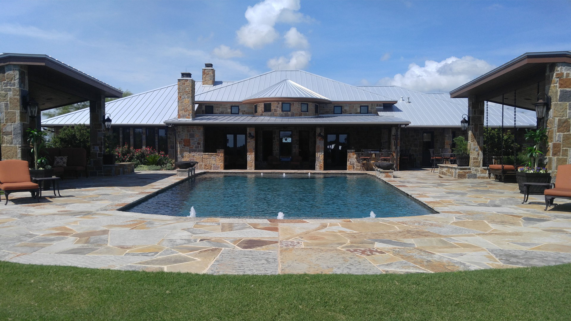 A large house with a large swimming pool in front of it
