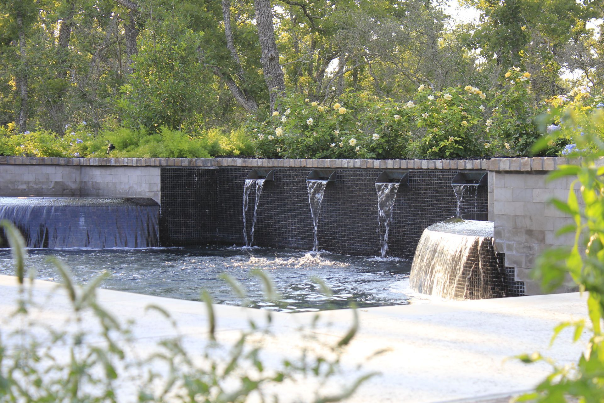 A waterfall in a park with trees in the background