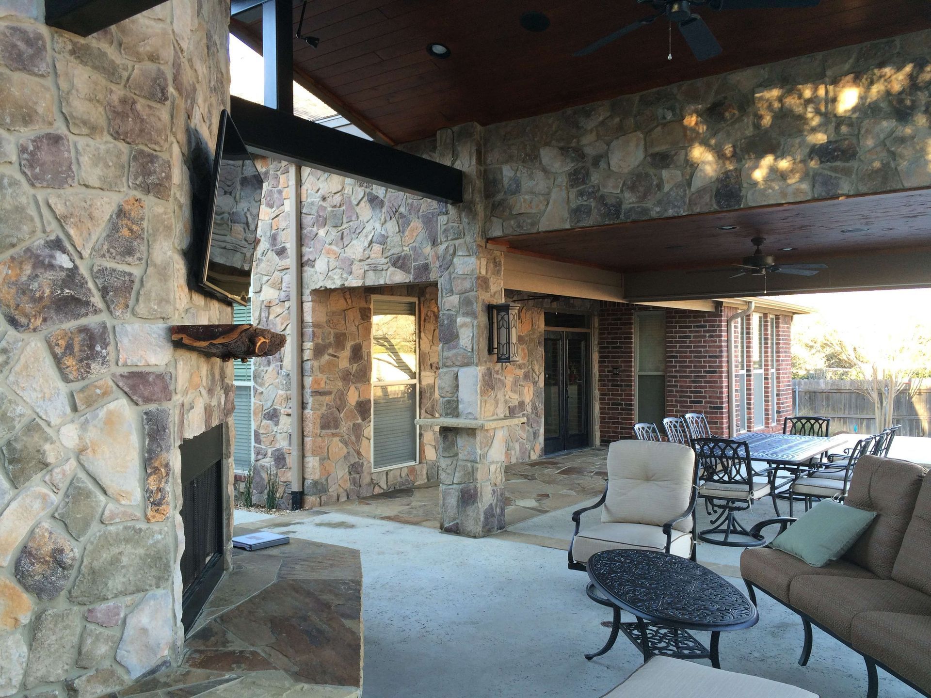 A patio with a fireplace and a couch and chairs
