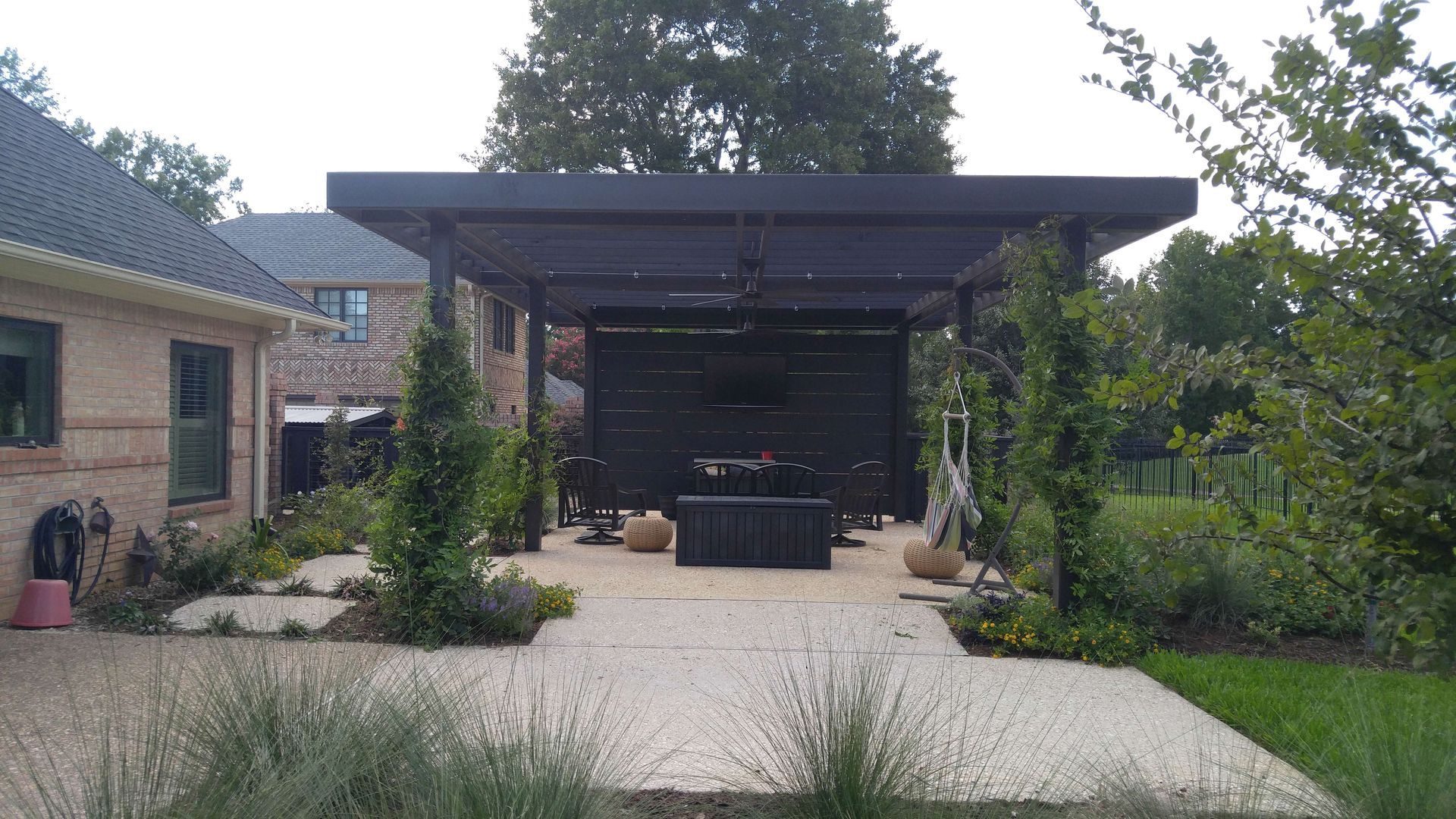 There is a pergola in the backyard of a house.