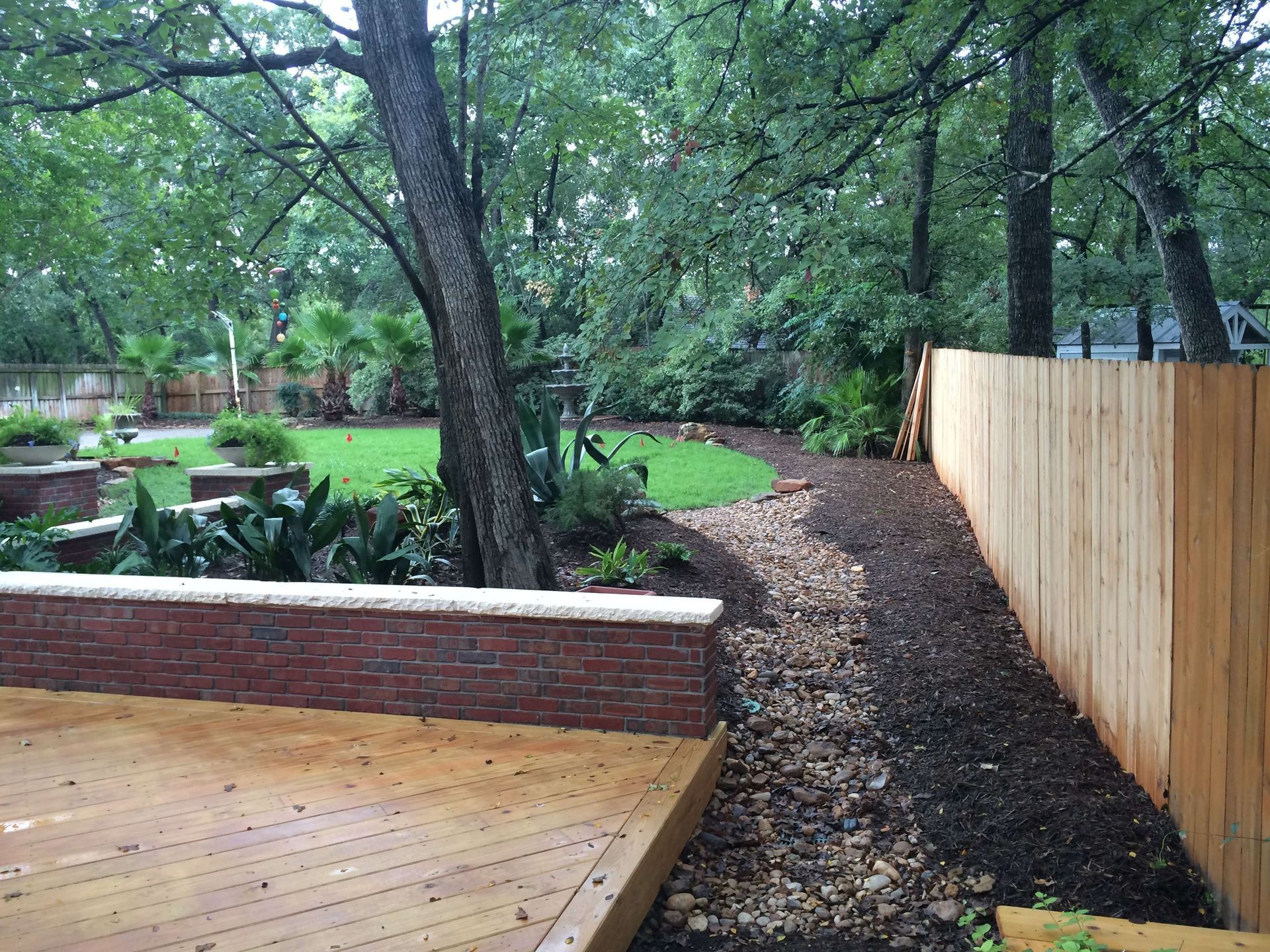 A wooden deck with a wooden fence surrounding it