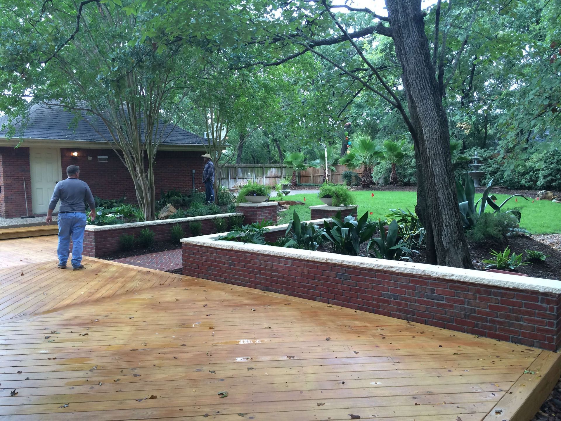 A man walking on a wooden deck in front of a house