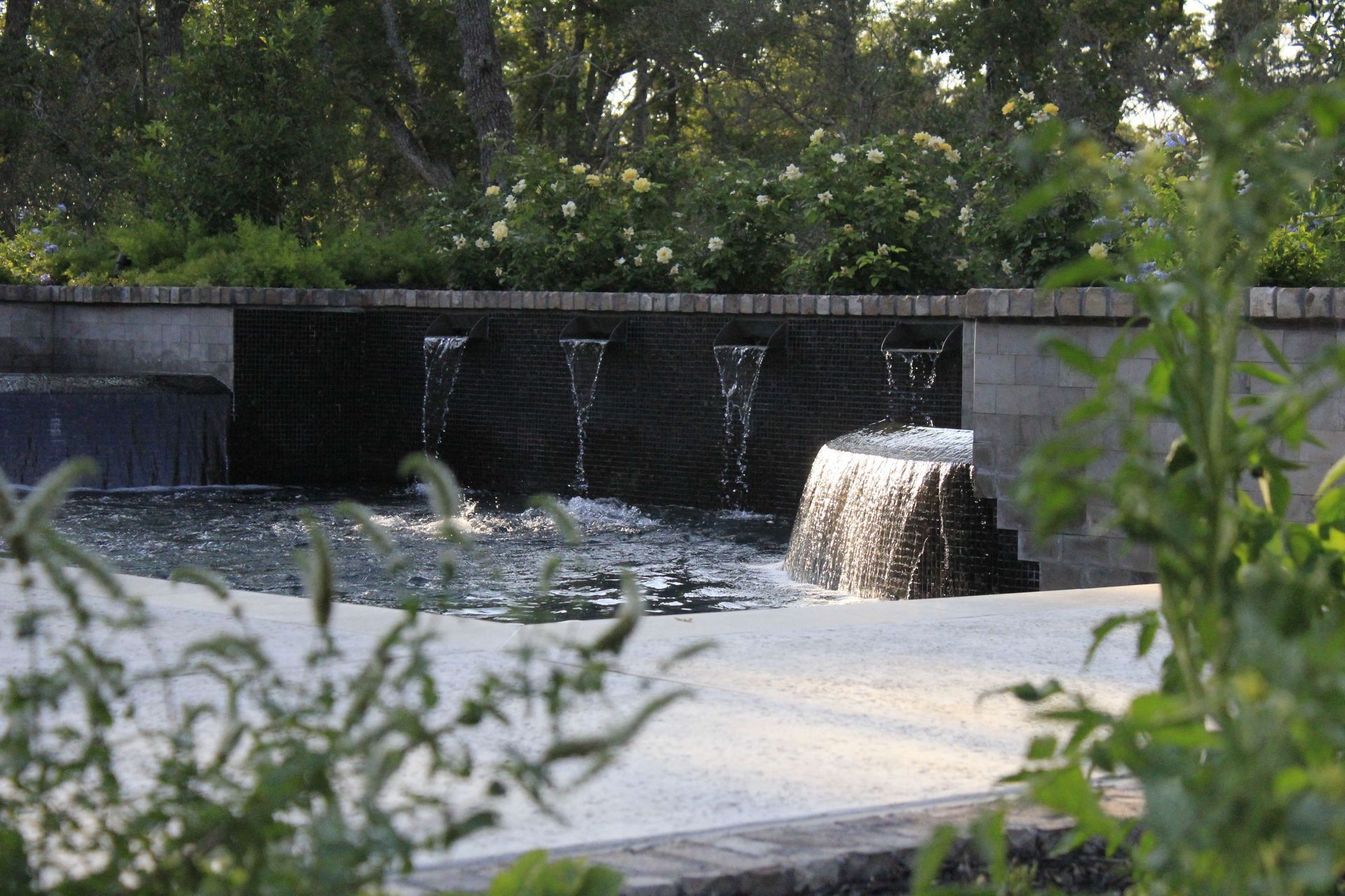 A swimming pool with a fountain in the middle of it