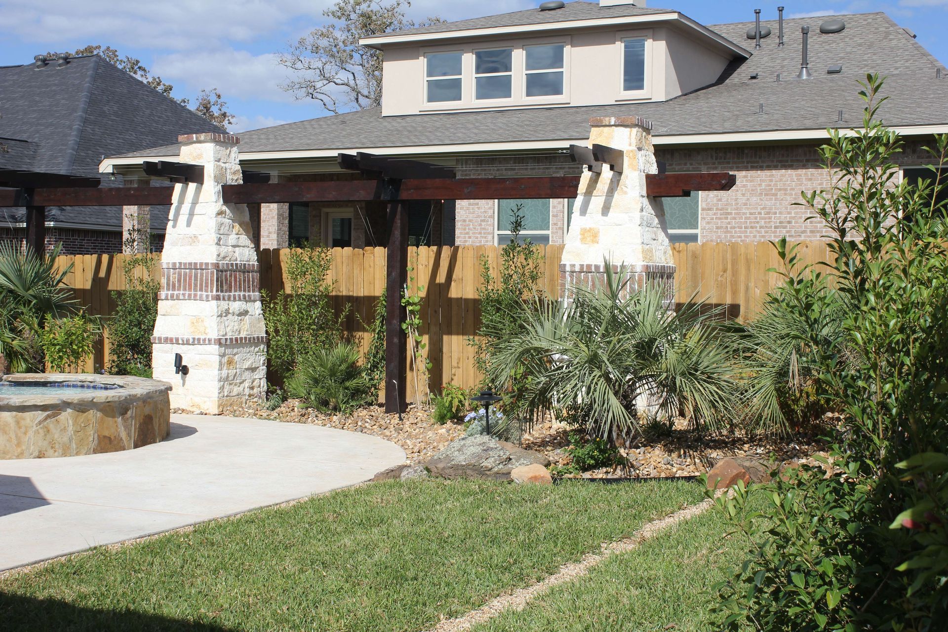 A large house with a fence and a fireplace in the backyard