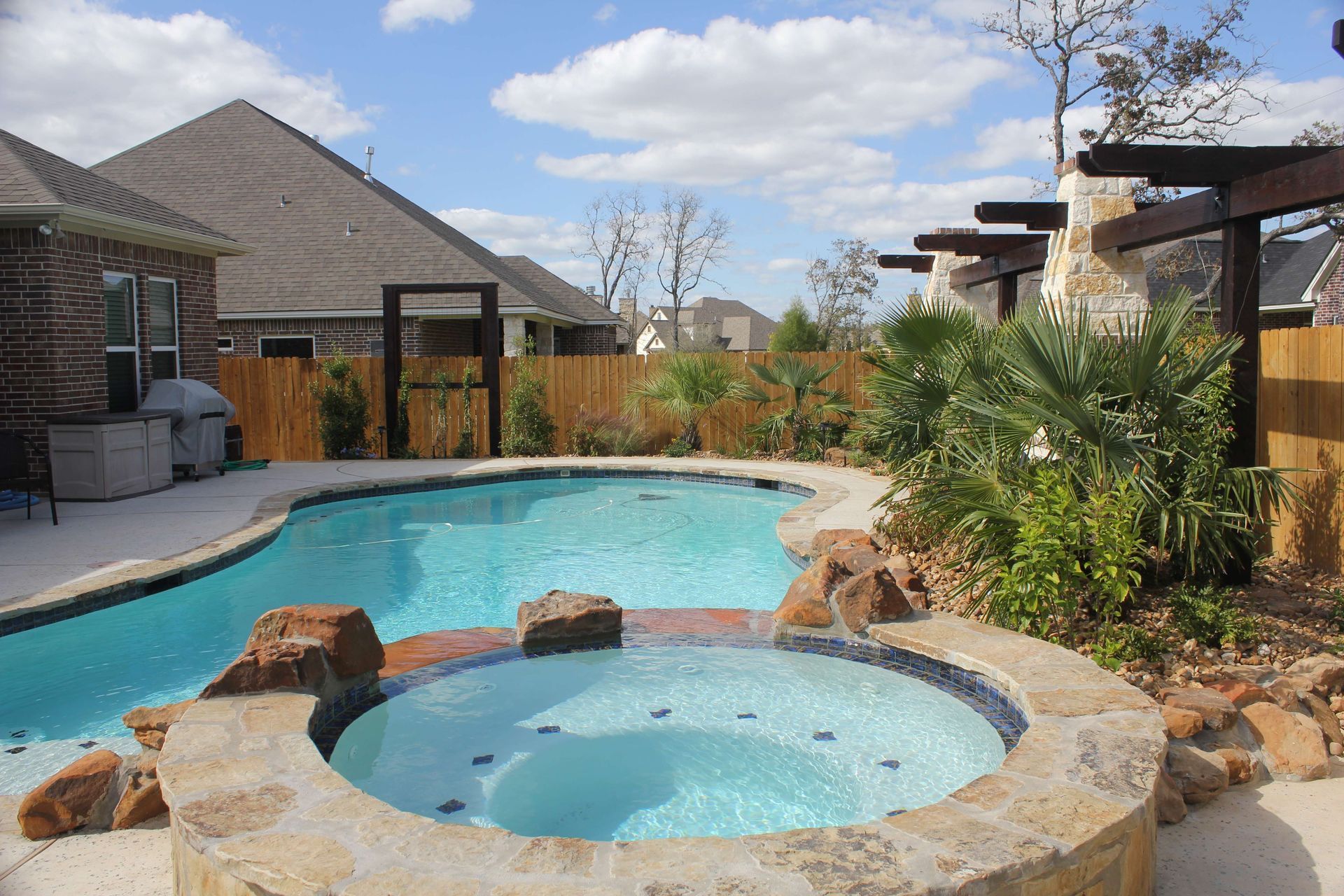 A large swimming pool with a hot tub in the middle