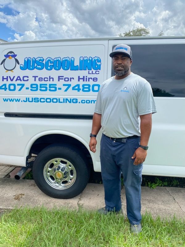 Man in work uniform stands by a white van with