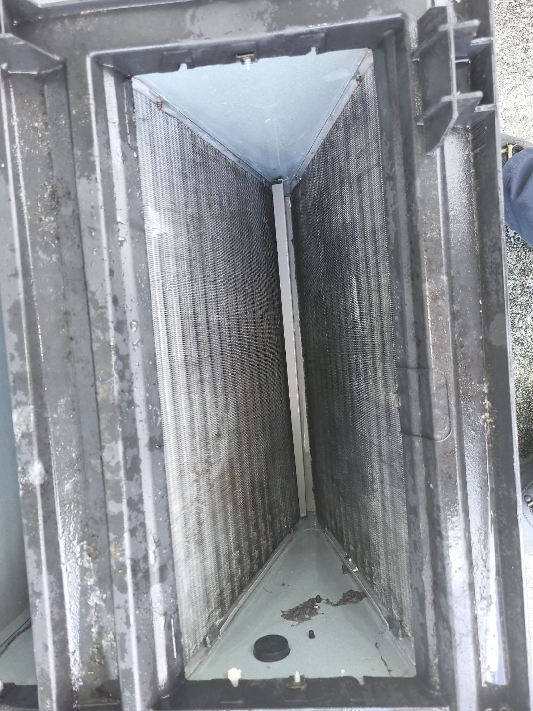 A dirty air vent with a hole in the middle of it.