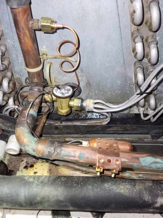 A close up of a copper pipe with a valve on it