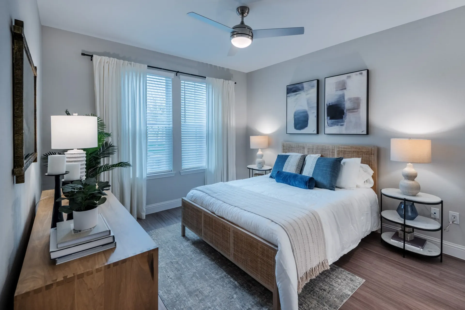 Bedroom with a queen-size bed, nightstands, dresser, and ceiling fan.