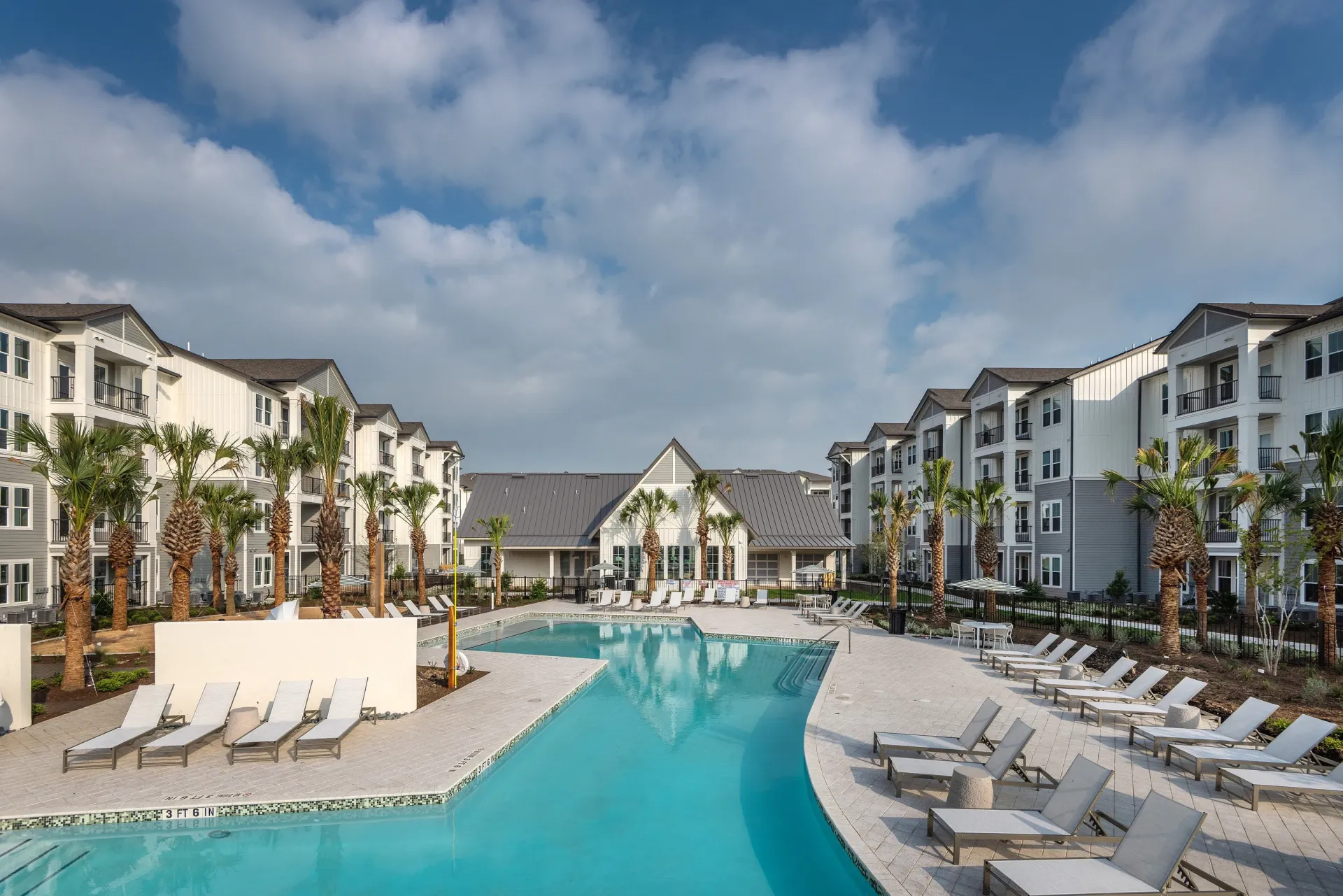 Swimming pool and lounge chairs at a modern apartment complex.