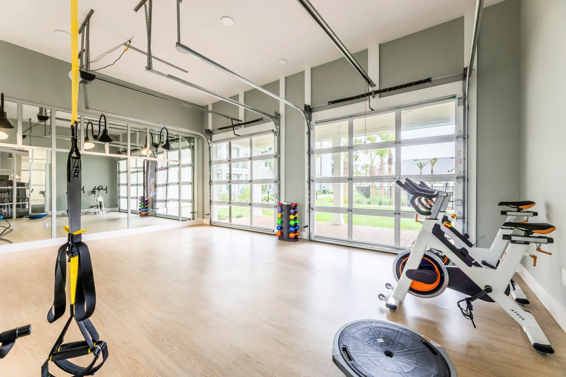 Gym with spin bikes, TRX straps, and large windows.