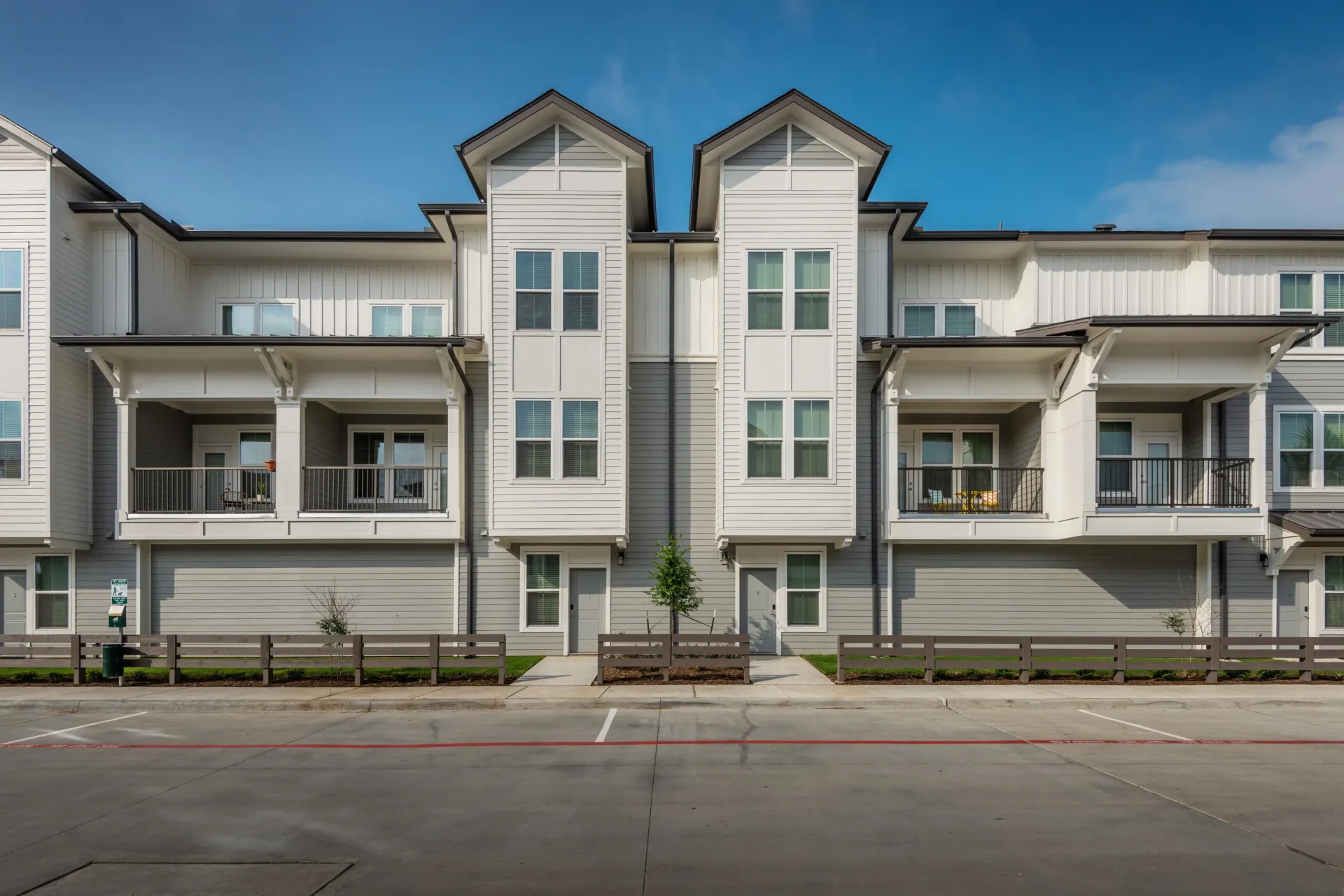 Exterior view of a modern apartment building with balconies and large windows.