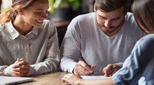 Young Couple Signing Papers — Deerfield Beach, FL — Blade & Blade P.A.