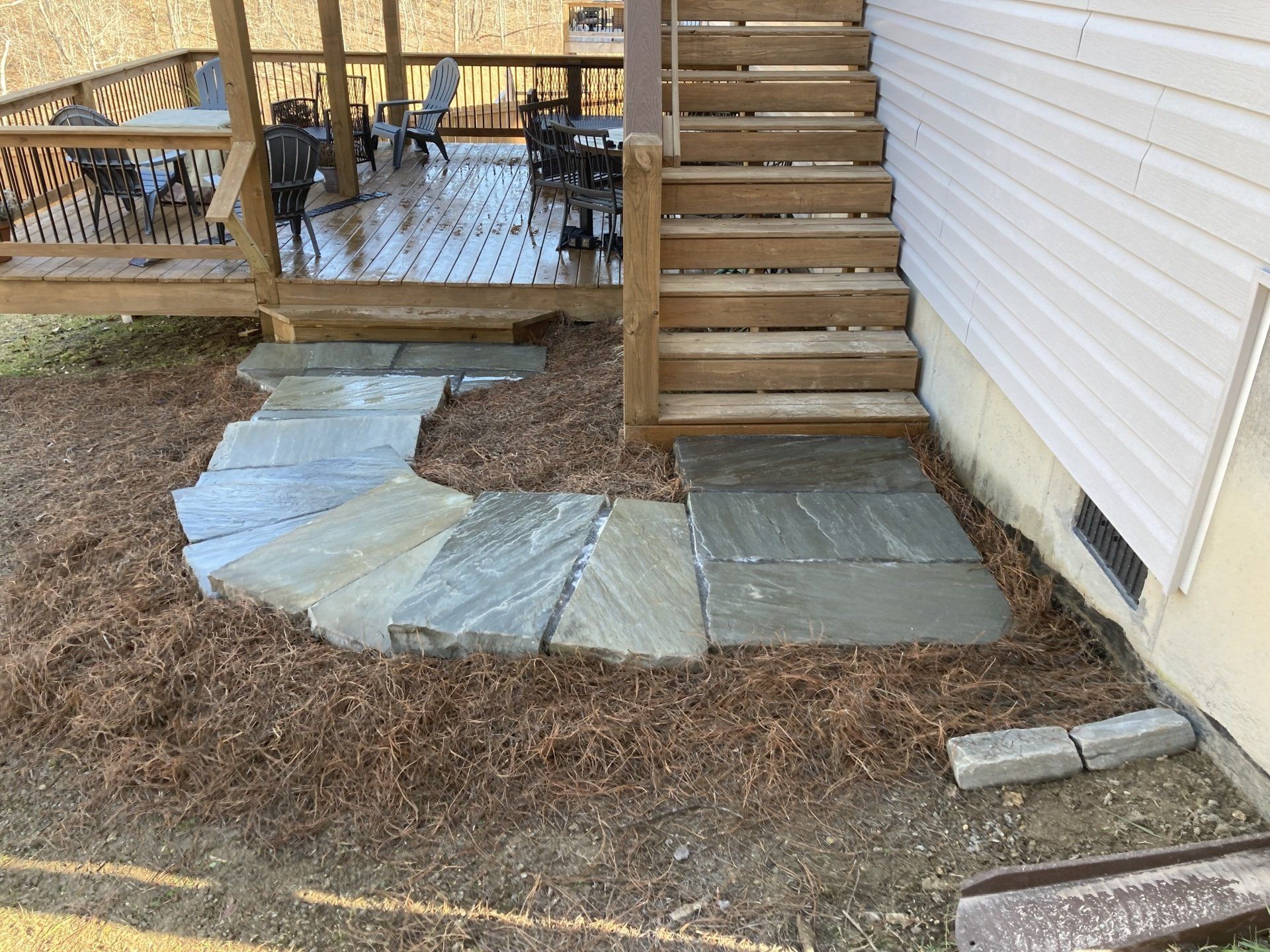 A stone walkway leading to a deck and stairs.