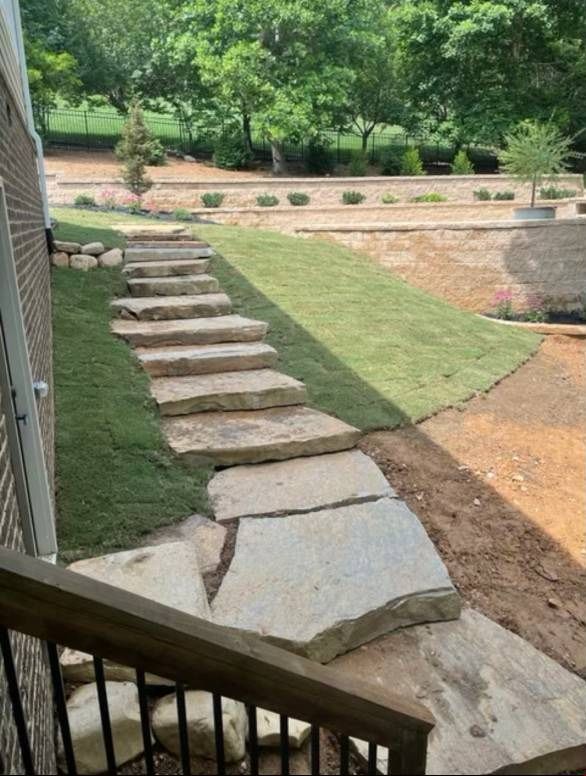 A stone walkway leading to a lush green yard.