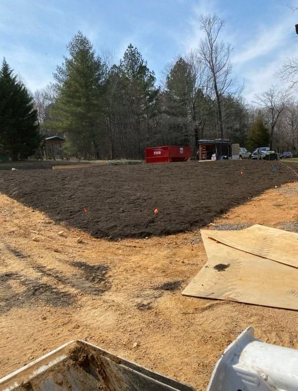 A large pile of dirt is sitting in the middle of a dirt field.
