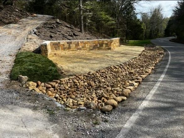 A road with a stone wall on the side of it.