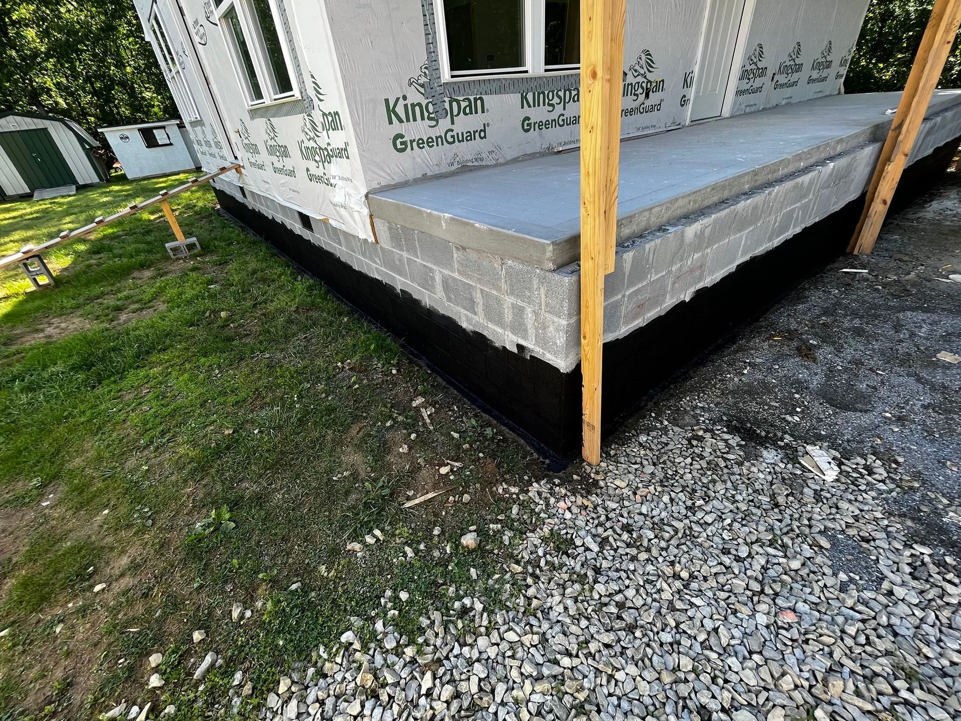 A house is being built on a gravel lot.