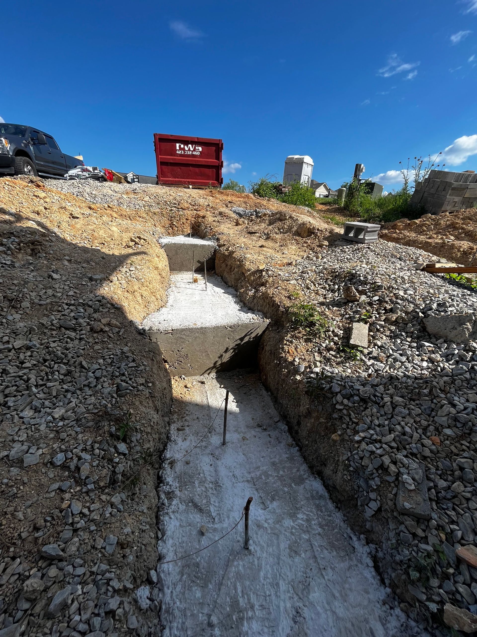 A construction site with a red dumpster in the background.