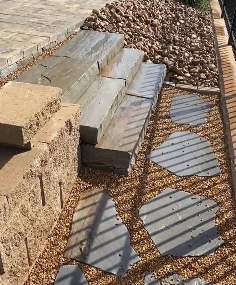 A stone walkway with steps and stepping stones in a garden.