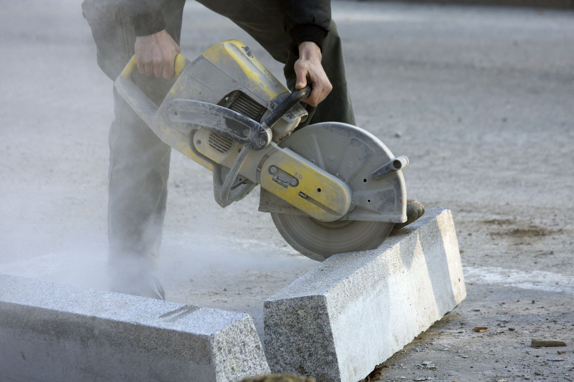 Ein Mann schneidet einen Betonblock mit einer Kreissäge.