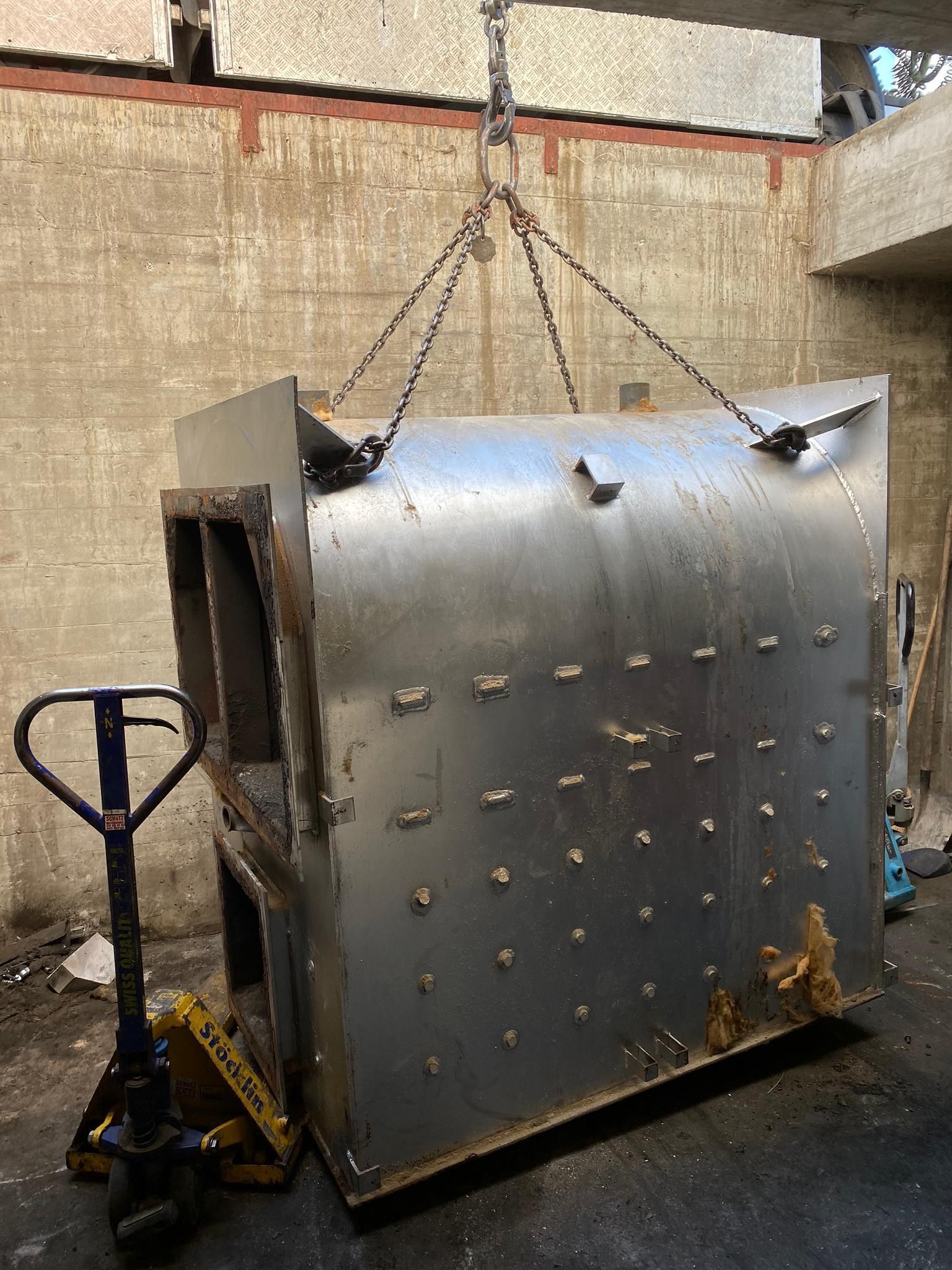 Ein großes Metallobjekt wird von einem Kran angehoben.