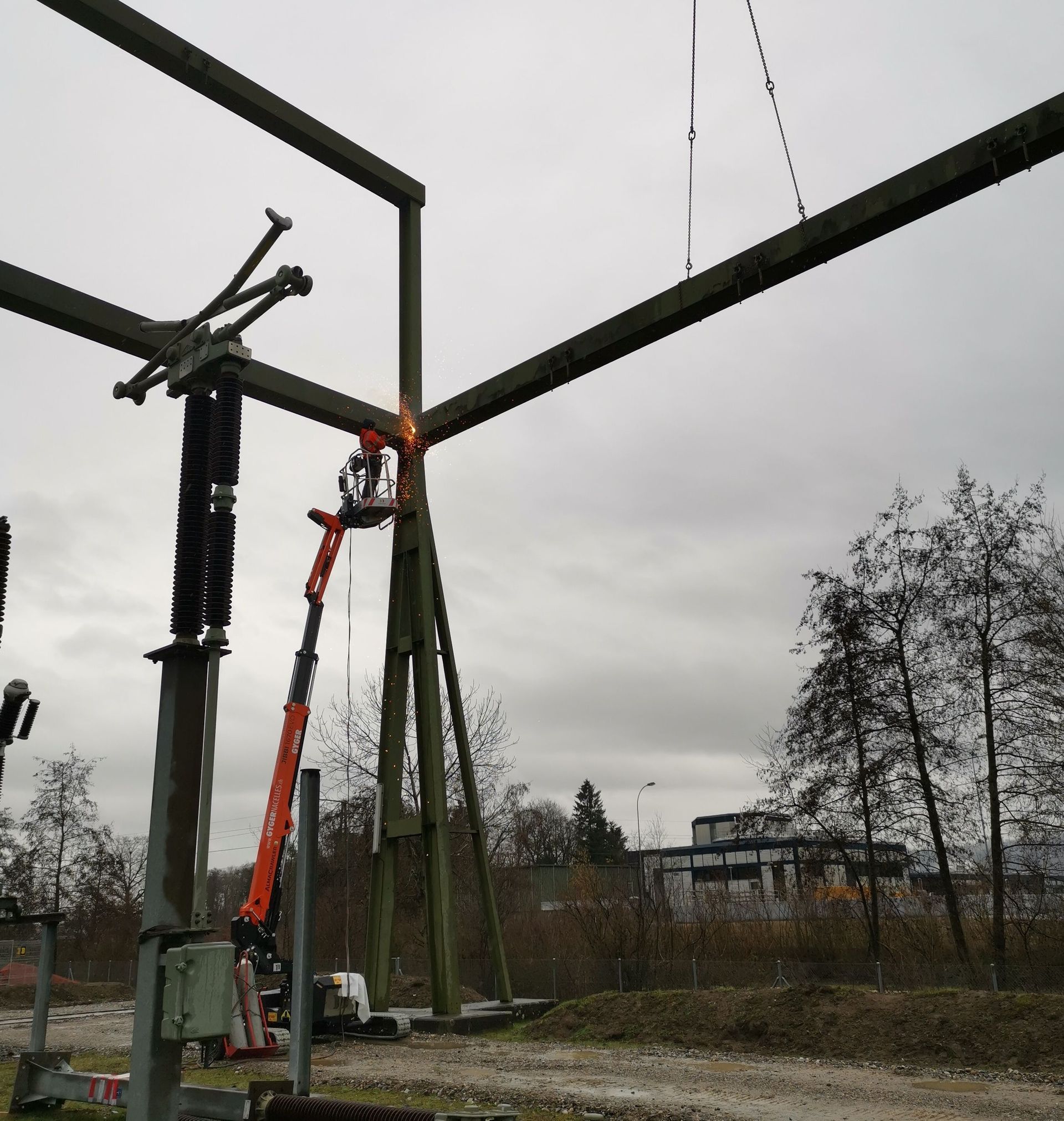Ein Kran wird zum Anheben einer großen Metallkonstruktion verwendet.